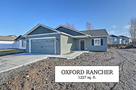 A blue house with a sign that says " oxford rancher 1 2 2 7 sq. Ft ".