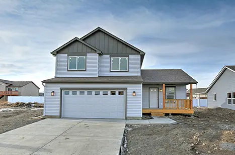 A house with a garage and driveway in front of it.